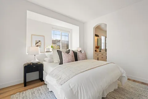 a bedroom with a bed and wooden floor