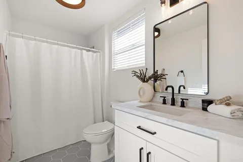 a bathroom with a sink a toilet and a mirror