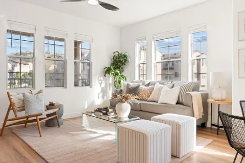 a living room with furniture wooden floor and a large window