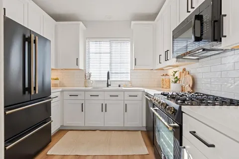 a kitchen with stainless steel appliances a stove sink and refrigerator