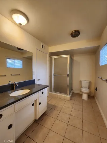 a spacious bathroom with a granite countertop sink a toilet and a mirror