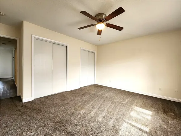 an empty room with a window and a fan