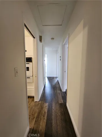 a view of a hallway with wooden floor and closet