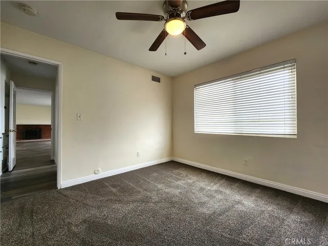an empty room with fan and windows