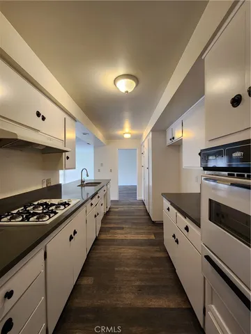 a kitchen with granite countertop a stove and a refrigerator