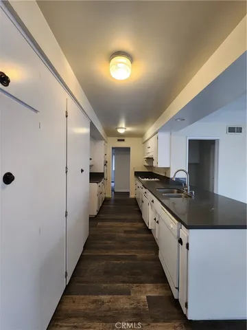 a large kitchen with lots of counter space and wooden floor