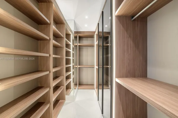 a view of an empty room with windows and closet