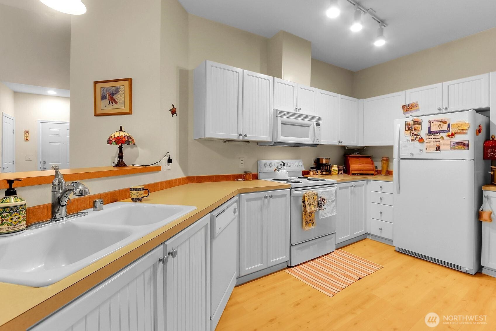 1500 South 18th Street, Unit F202 Renton, WA 98055 - Photo 9 of 20 a kitchen with a sink a refrigerator and cabinets