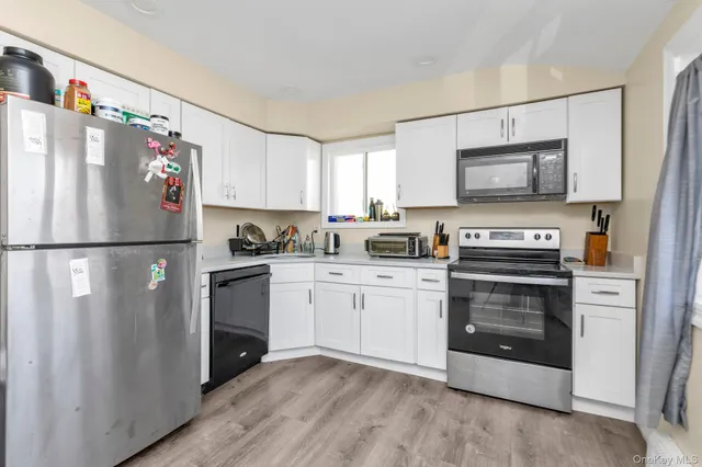 a kitchen with stainless steel appliances granite countertop a refrigerator stove a sink and a microwave