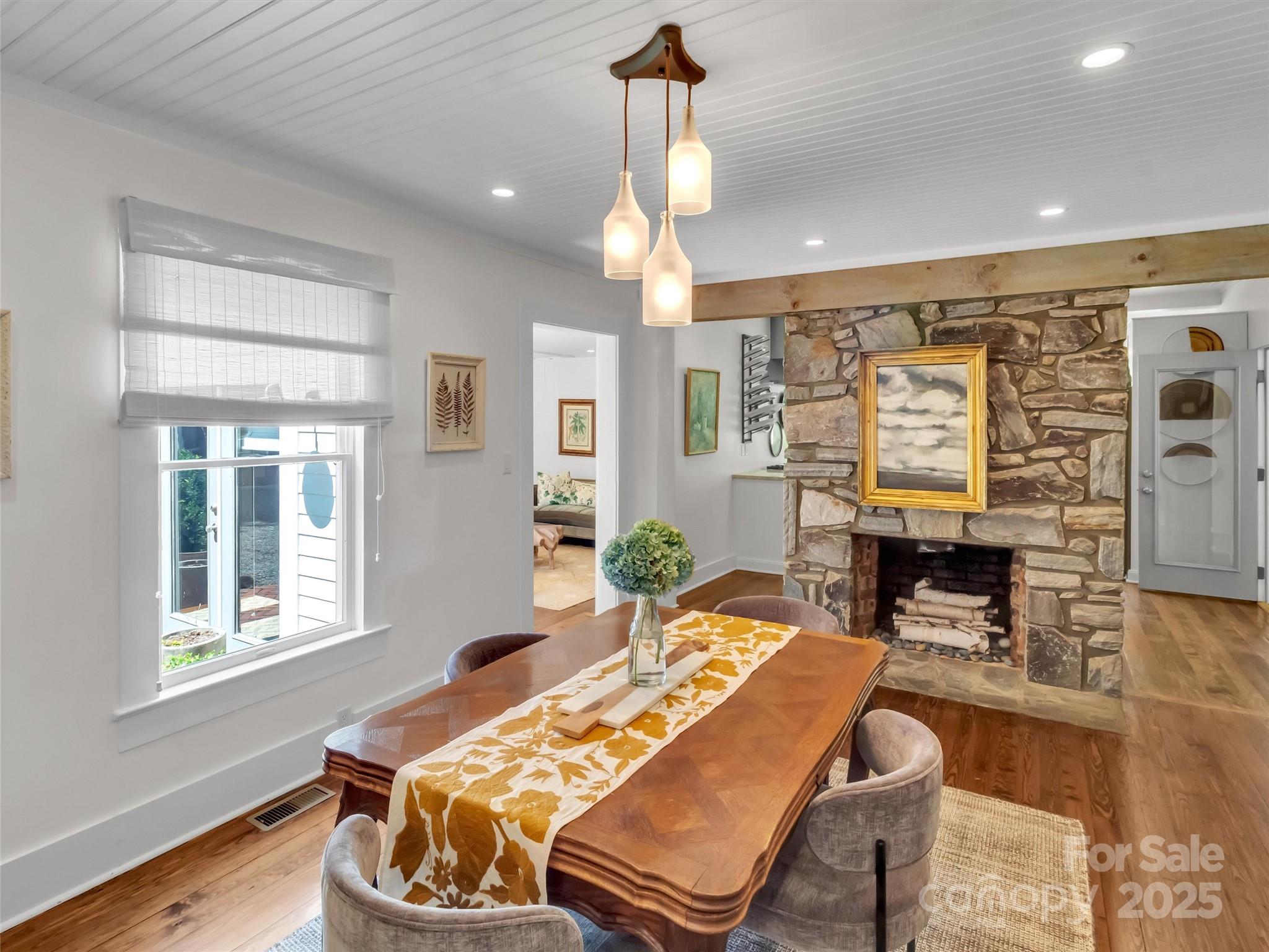 88 Plott Valley Road Waynesville, NC 28786 - Photo 8 of 48 a dining room with wooden floor a chandelier a glass table and chairs