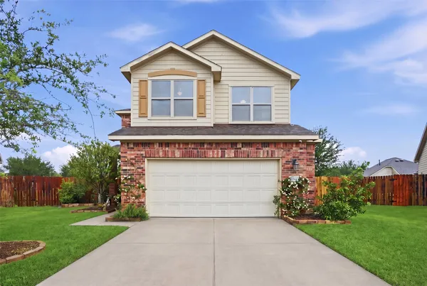a front view of a house with a garden and garage