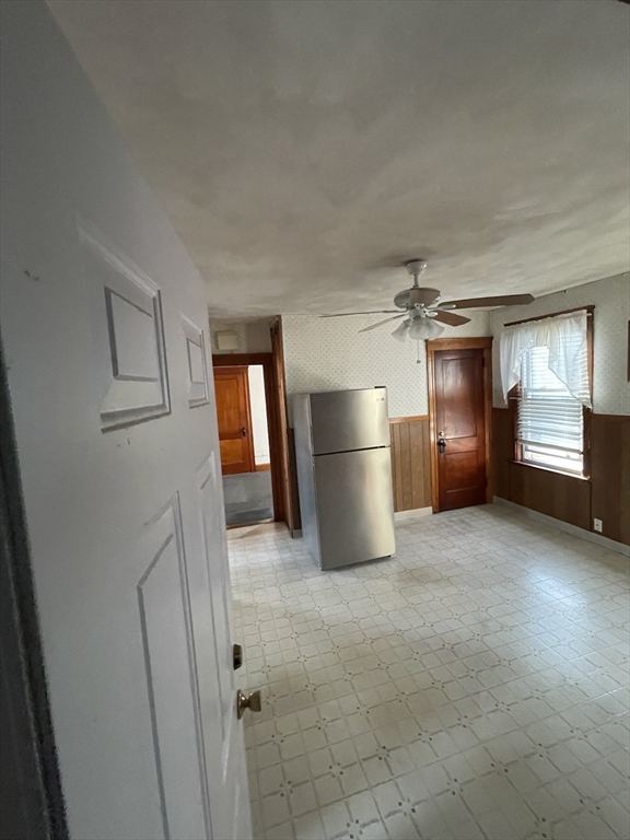 a view of an empty room and a kitchen