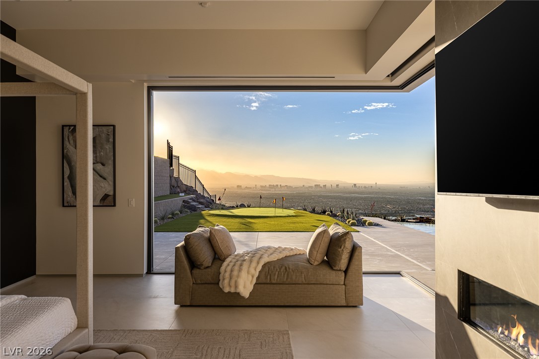 563 Grand Rim Drive Henderson, NV 89012 - Photo 22 of 70 Retreat to this primary bedroom offering a cozy fireplace and panoramic views of the city.