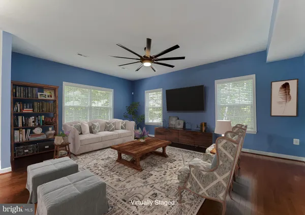 a living room with furniture a flat screen tv and a large window