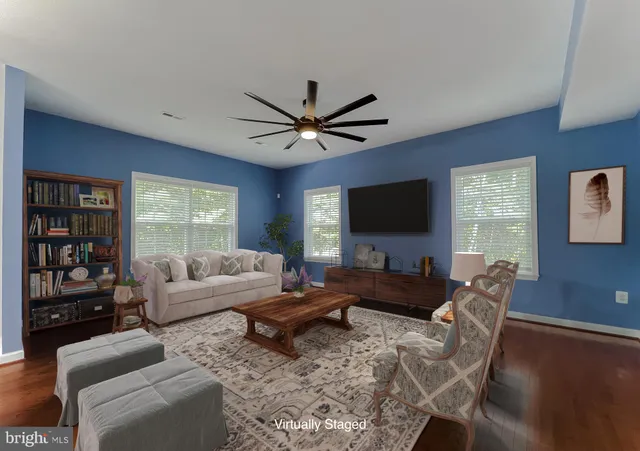 a living room with furniture a flat screen tv and a large window