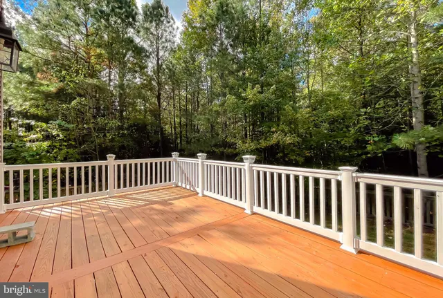 a balcony with wooden floor and trees