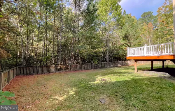 a view of a house with backyard and a tree