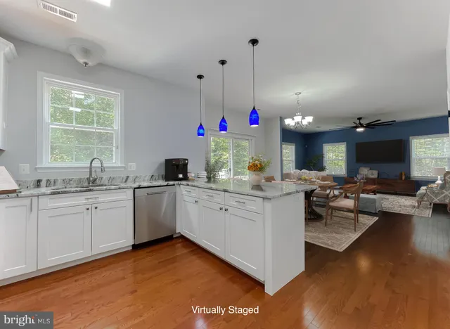 a kitchen with granite countertop a stove and white cabinets