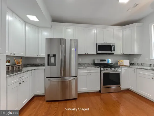 a kitchen with stainless steel appliances granite countertop a refrigerator stove a sink and a microwave