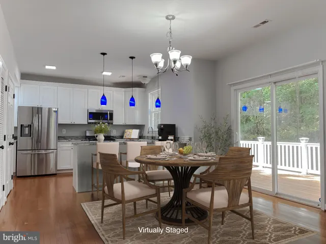 a view of a dining room with furniture a chandelier and wooden floor