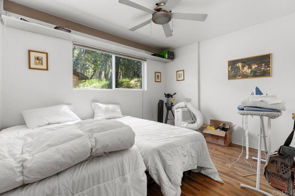 29560 Lilac Road Valley Center, CA 92082 - Photo 30 of 43 a bedroom with a bed and wooden floor