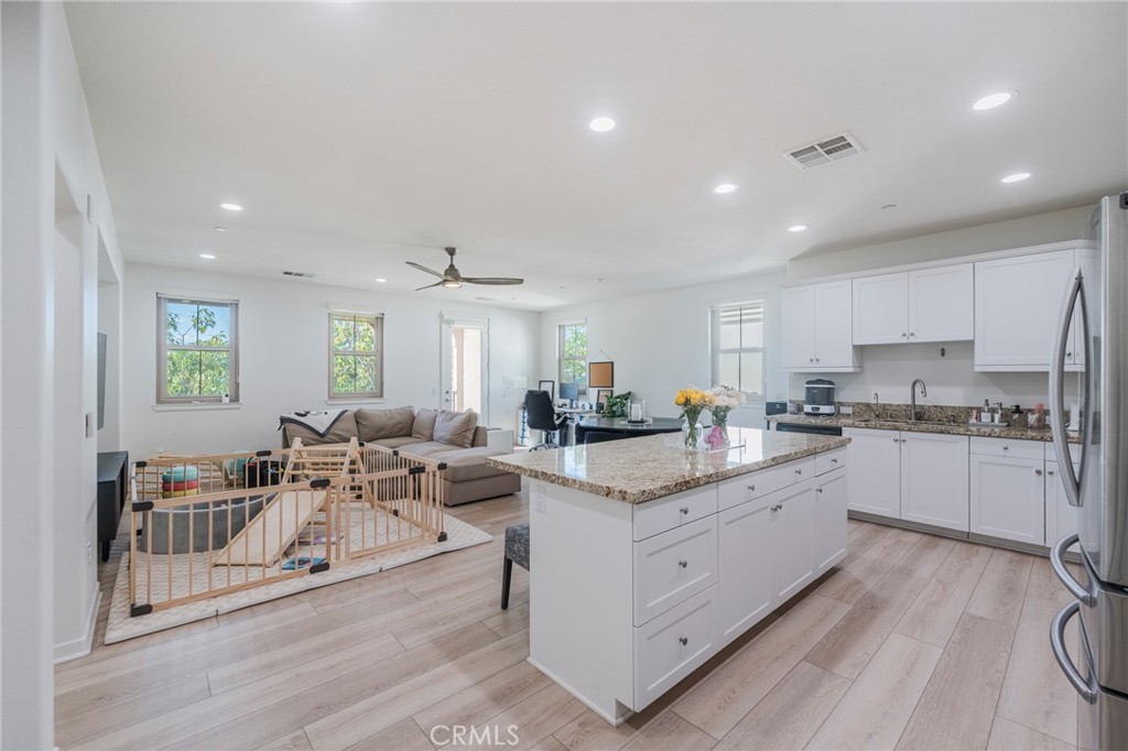 409 Mallorca Lane Brea, CA 92823 - Photo 4 of 40 a large white dining hall with stainless steel appliances granite countertop a lot of cabinets and wooden floor