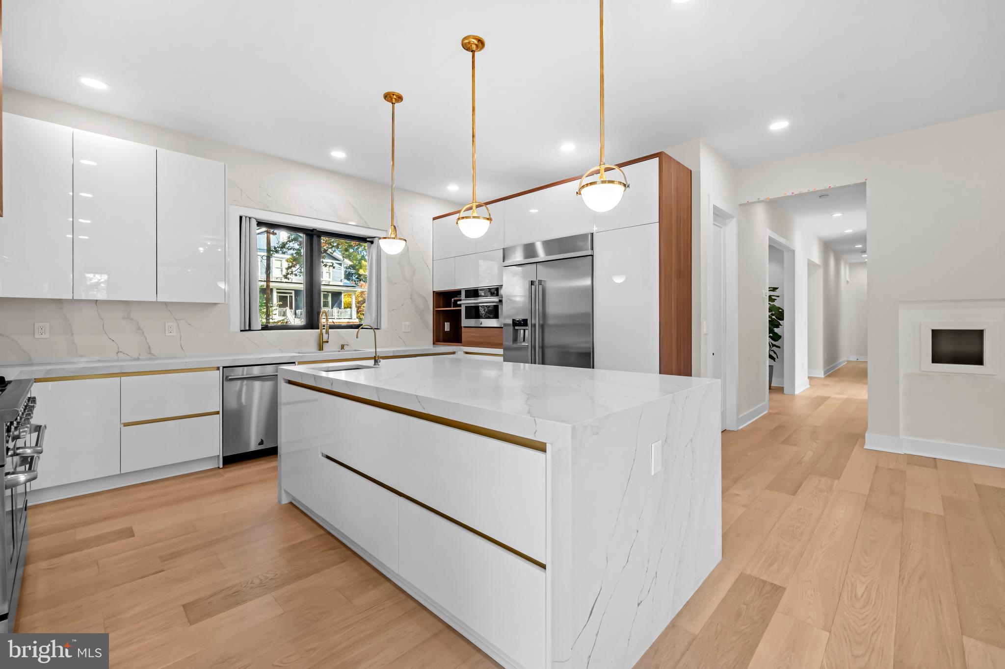 4246 15th Street North Arlington, VA 22207 - Photo 13 of 72 a kitchen with stainless steel appliances kitchen island granite countertop a refrigerator a sink dishwasher a stove and white cabinets with wooden floor