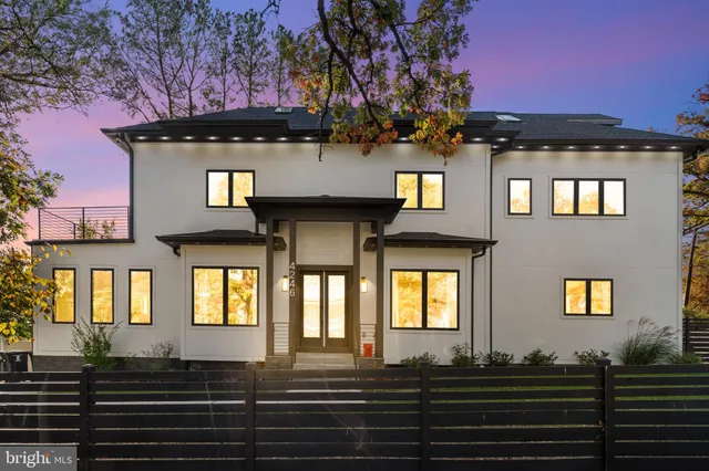 a front view of a house with a yard and potted plants