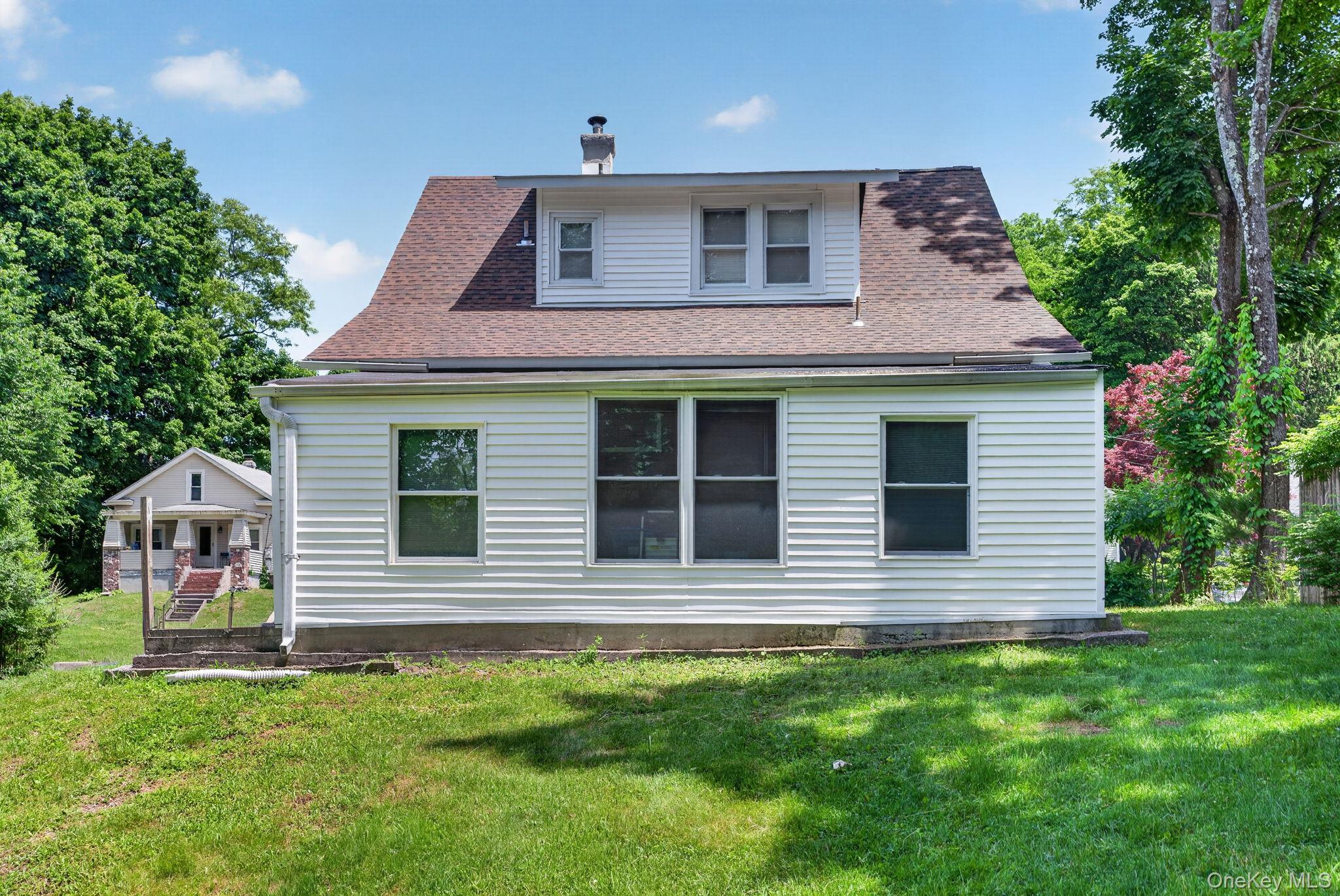 7 Walnut Street Poughkeepsie, NY 12601 - Photo 25 of 30 The rear exterior of this charming Cape Cod home is both inviting and functional, offering a wonderful extension of the living space. The classic architectural design is complemented by attractive siding, mature landscaping, and a spacious backyard perfect for outdoor enjoyment.