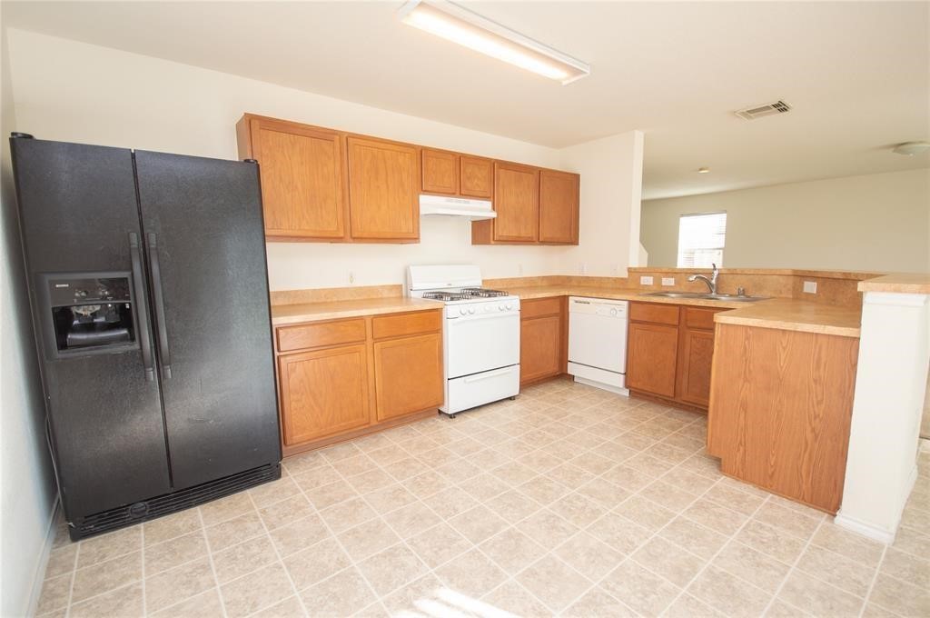 310 Falling Pine Drive Conroe, TX 77304 - Photo 7 of 15 a kitchen with stainless steel appliances granite countertop a refrigerator and a stove top oven