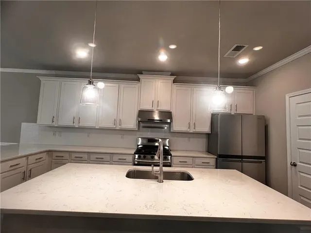 a kitchen with a sink stainless steel appliances and counter space