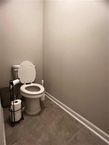 a white toilet sitting next to a white wall