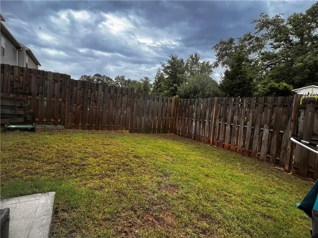 a view of backyard with wooden fence