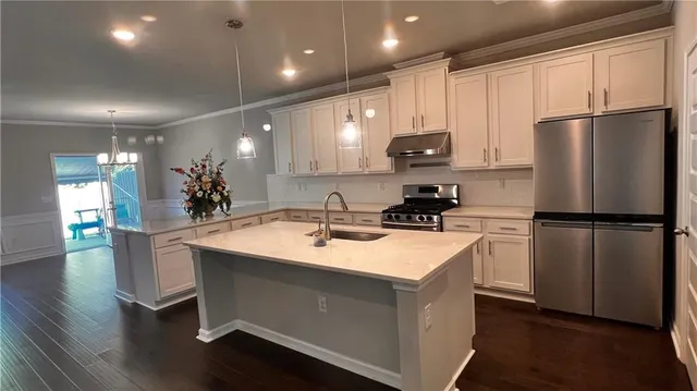 a kitchen with a sink a refrigerator and cabinets