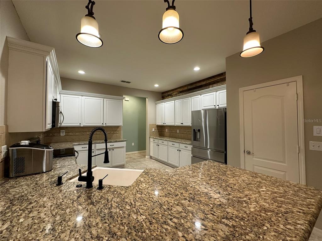 3008 Boat Lift Road Kissimmee, FL 34746 - Photo 15 of 56 a kitchen with stainless steel appliances granite countertop a sink refrigerator stove and microwave