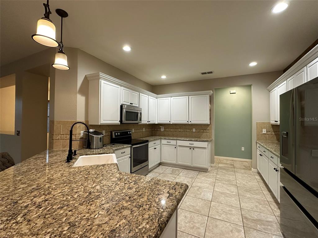 3008 Boat Lift Road Kissimmee, FL 34746 - Photo 16 of 56 a large kitchen with kitchen island a sink stainless steel appliances and cabinets