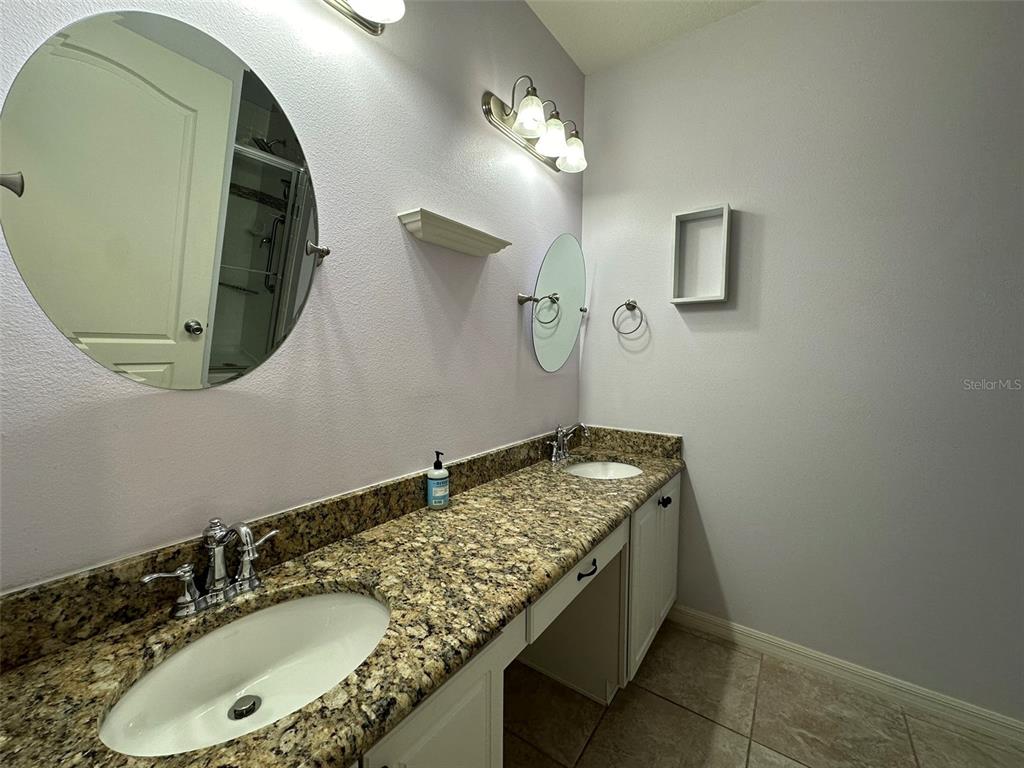 3008 Boat Lift Road Kissimmee, FL 34746 - Photo 30 of 56 a bathroom with a granite countertop double vanity and a mirror