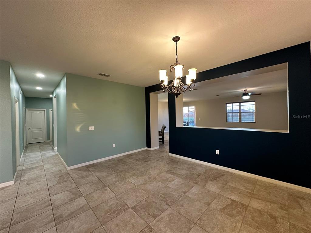 3008 Boat Lift Road Kissimmee, FL 34746 - Photo 9 of 56 a view of a hallway with a chandelier and fireplace