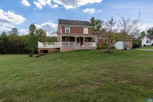 a front view of a house with a garden and trees