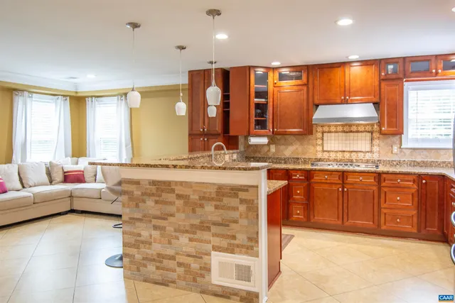 a kitchen with granite countertop a sink stove and cabinets