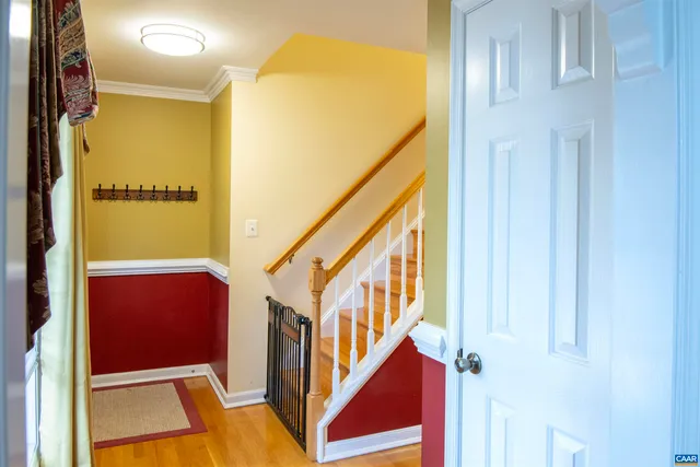 a view of hallway with wooden floor and flat screen tv