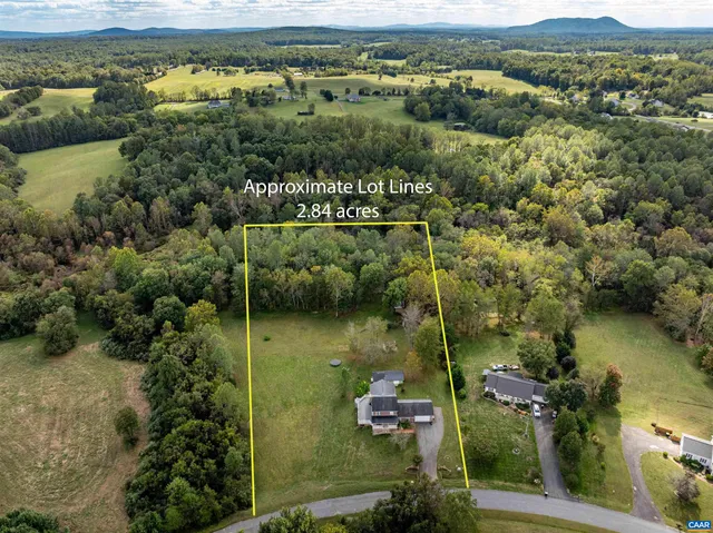 an aerial view of ocean with residential house with outdoor space and trees