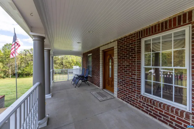 a view of an empty room with a floor to ceiling window and wooden floor