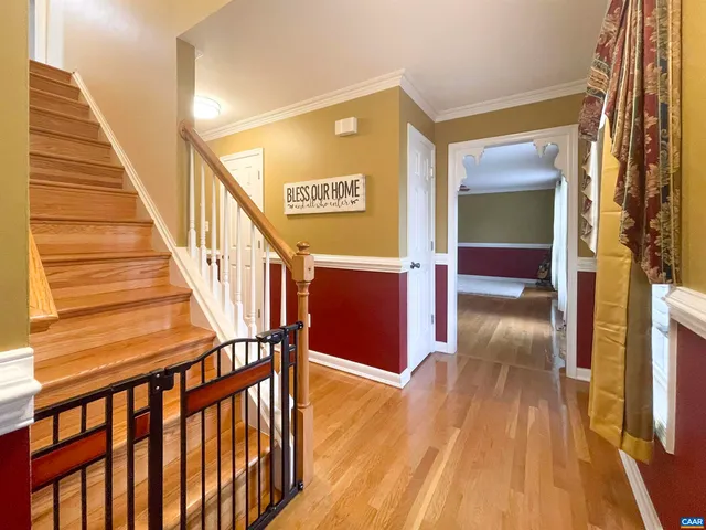 a view of a hallway with wooden floor and staircase