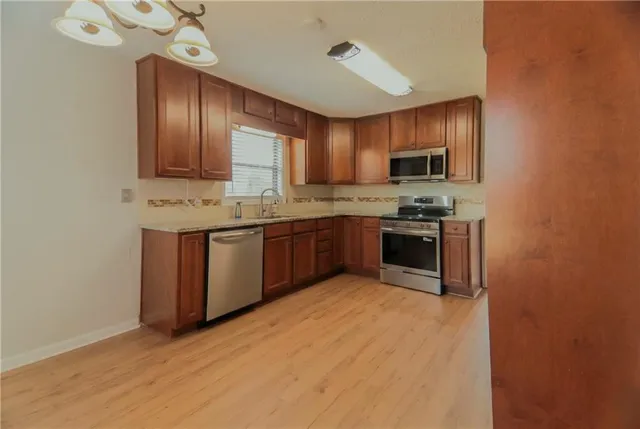 a kitchen with stainless steel appliances granite countertop a stove sink and cabinets