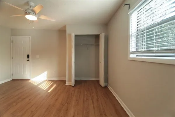 an empty room with wooden floor and windows