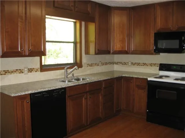 a kitchen with a sink a window and cabinets