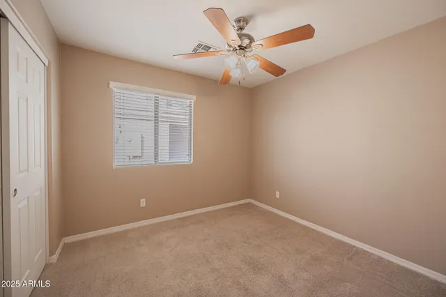 an empty room with windows and fan