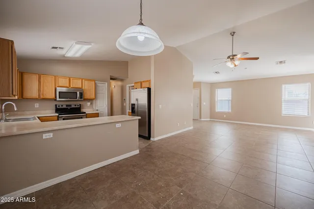 a kitchen with stainless steel appliances granite countertop a refrigerator a stove a sink dishwasher and white cabinets with wooden floor