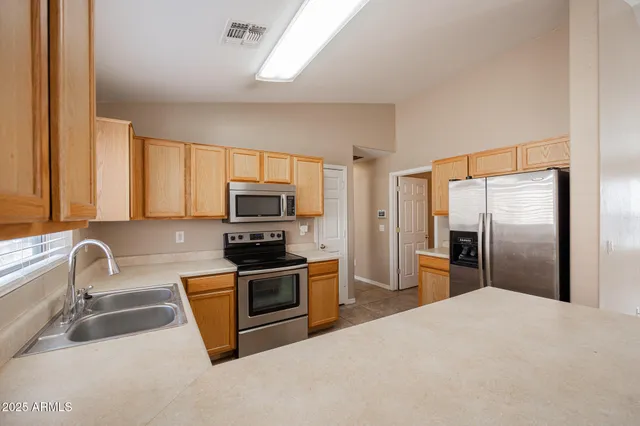 a kitchen with granite countertop a refrigerator and a sink